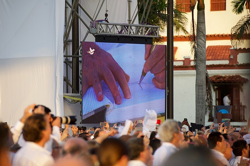 A screen showing the signing of the initial peace accord in Cartagena on 26 September 2016; the revised final agreement followed in November.